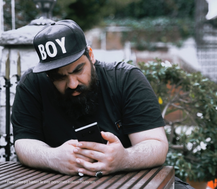 bearded-man-cap-looking-at-phone